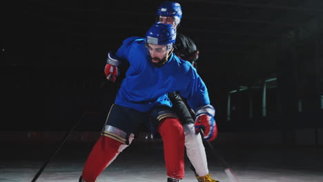 Two-man-playing-hockey-on-ice-rink.-hockey-Two-hockey-players-fighting-for-puck.-STEADICAM-SHOT